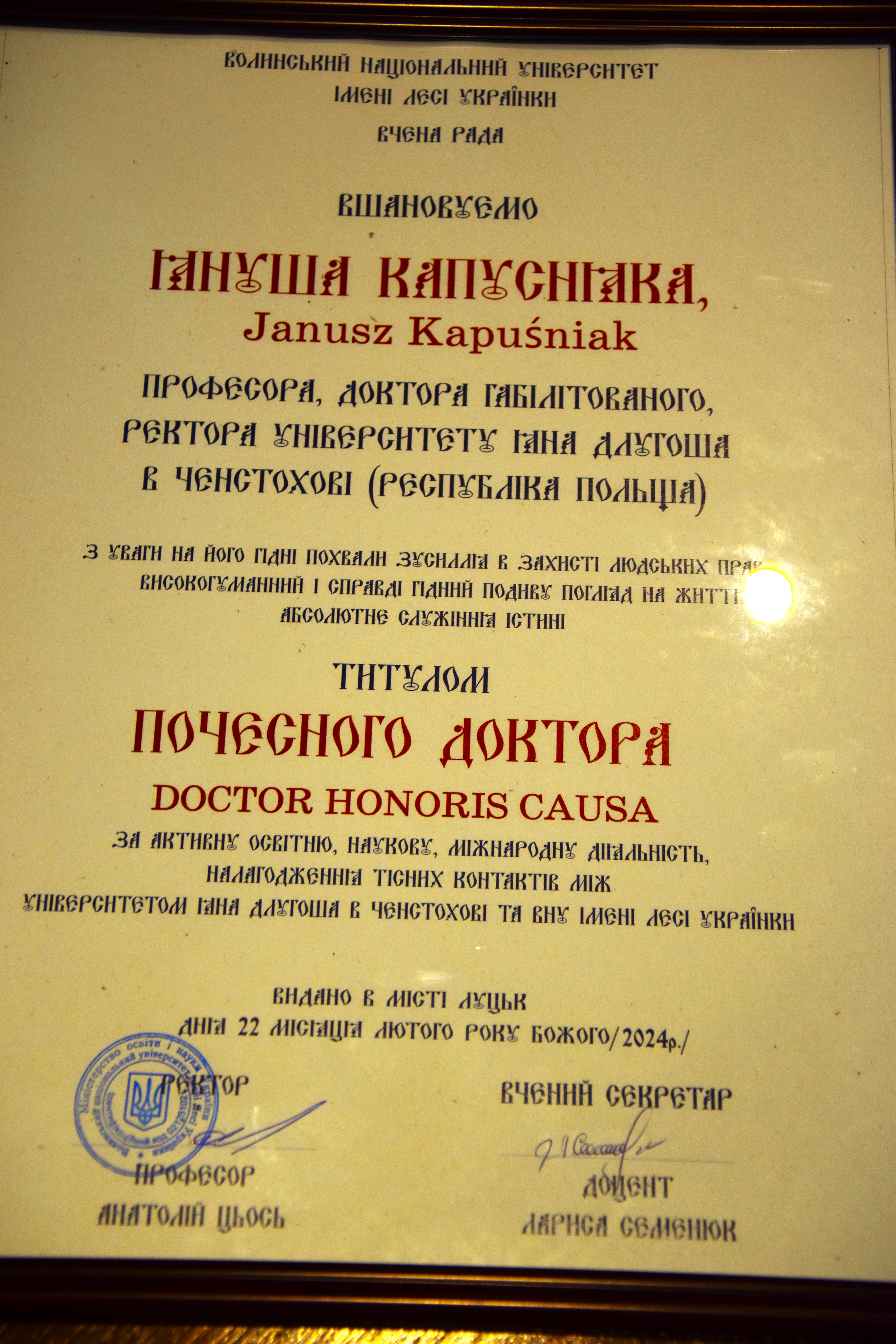 On the diploma:   "Lesya Ukrainka Volyn National University in Lutsk  Academic Council  Honored professor, habilitated doctor, Rector-elect of Jan Dlugosz University in Czestochowa (RP) for his worthy efforts to protect human rights, highly human and truly admirable outlook on life, absolute service to the truth with the title of doctor honoris causa for active educational, scientific, international activity, establishing close contacts between Jan Dlugosz University in Czestochowa and Lesya Ukrainka University, issued in the city of Lutsk on February 22, 2024."